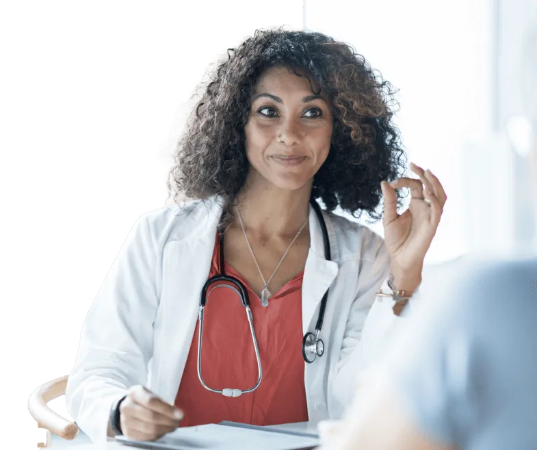 Doctor smiling in a meeting with a patient off screen.